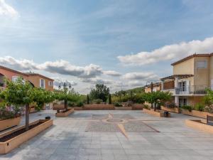 een binnenplaats met bomen en gebouwen op een bewolkte dag bij D de Camiole A N102 ST2 in Callian +3 foto's