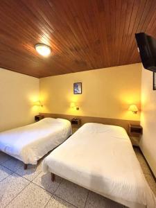 a room with two beds and a wooden ceiling at Les Loges du Vercors in Vizille