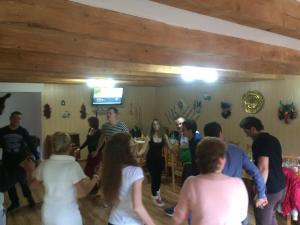 a group of people dancing in a room at Casa de Vacanta Neagu in Gura Teghii