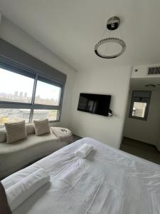 een slaapkamer met een wit bed en een groot raam bij Your Next Premium Stay In Ashdod in Ashdod