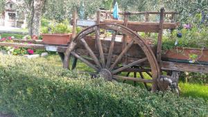 un viejo carro de madera con una rueda en un jardín en Appartamenti Ceccherini en Malcesine