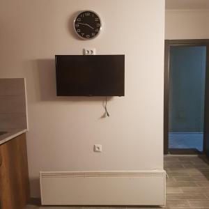 een flatscreen-tv aan een muur met een klok bij Ski Resort Bakuriani in Bakuriani