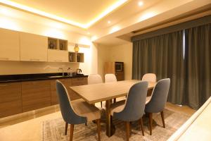 eine Küche und ein Esszimmer mit einem Holztisch und Stühlen in der Unterkunft Jewel Sharm El Sheikh Hotel in Sharm El Sheikh