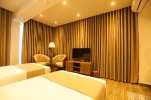 ein Hotelzimmer mit zwei Betten und einem Fernseher in der Unterkunft Jewel Sharm El Sheikh Hotel in Sharm El Sheikh