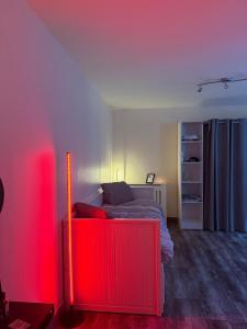 een slaapkamer met een bed met een rood licht bij Studio cosy et calme à Garches in Garches +6 foto's