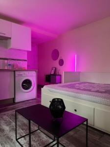 een paarse kamer met een bed en een wasmachine bij Studio cosy et calme à Garches in Garches