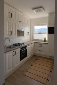 a kitchen with white cabinets and a sink and a window at Apartament przy Norweskim in Jelenia Góra