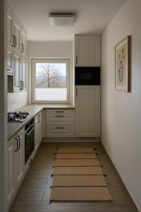a kitchen with white cabinets and a window at Apartament przy Norweskim in Jelenia Góra +7 photos