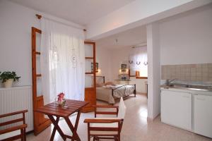 a kitchen and living room with a table and chairs at Marlitsis Apartments & Studios in Skopelos Town
