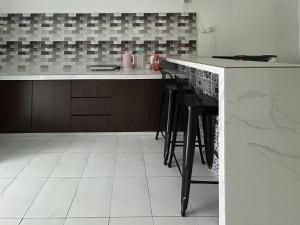 a kitchen with a counter and stools in it at Miraana Nest in Sungai Petani +8 photos