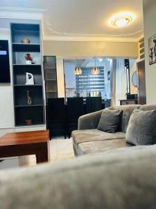 een woonkamer met een bank en een tafel bij Sunset Statehouse View Residence in Entebbe +27 foto's