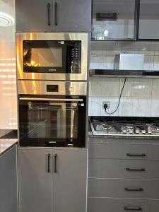 een keuken met 2 ovens en een magnetron bij Sunset Statehouse View Residence in Entebbe