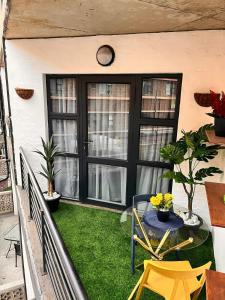 a balcony with grass and a table and a clock at Craftsmanship Unit 235 in Johannesburg