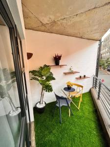 a small balcony with green grass and a table at Craftsmanship Unit 235 in Johannesburg