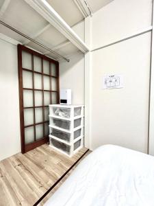 een witte kamer met een bed en een raam bij tkm北小岩1丁目203 in Tokyo