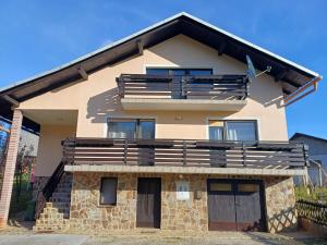 a house with a large balcony on top of it at KaTi Hiša in Koble