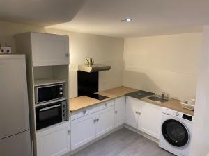 a small kitchen with white cabinets and a sink at The Provençal orchid in Malemort-du-Comtat