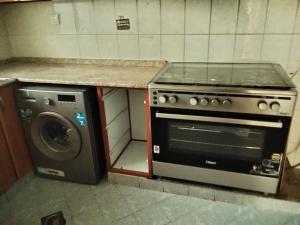 a kitchen with a stove and a washing machine at Orient Tower in Ajman 