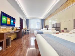 a hotel room with two beds and a flat screen tv at Yijingju Humanistic Inn in Zhangjiajie