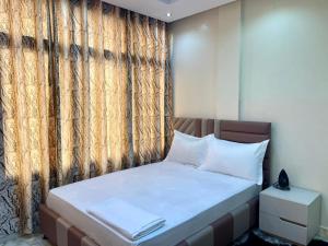 una piccola camera da letto con un letto e una finestra di Gombe243 a Kinshasa