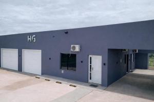 een groot blauw gebouw met twee witte garagedeuren bij 103-Quarto Pousada HG in Vila Nova do Sul