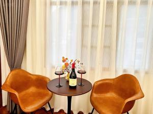 a table with two chairs and a bottle of wine at Yijingju Humanistic Inn in Zhangjiajie
