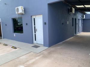 een kamer met een blauwe muur en een witte deur bij 103-Quarto Pousada HG in Vila Nova do Sul +3 foto's