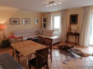 a living room with a couch and a table and chairs at Holiday Apartment Krumpendorf in Krumpendorf am Wörthersee +23 photos