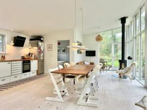 een keuken en eetkamer met een houten tafel en stoelen bij Modern Peninsula Cabin With Panoramic View in Piggaboda