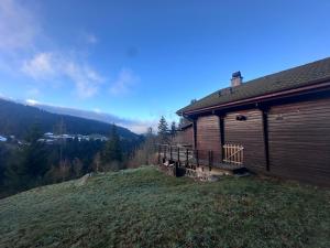 a building with a deck next to a mountain at Le Chalet des 4 Chouettes in Gérardmer