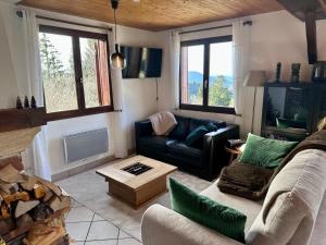a living room with a couch and a table at Le Chalet des 4 Chouettes in Gérardmer