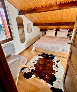 a bedroom with a bed and a rug on the floor at Le Chalet des 4 Chouettes in Gérardmer
