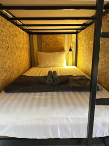 a bed with a pair of shoes sitting on it at Sunnies 24 in Phra Ae beach