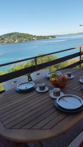 a wooden table with plates and bowls of fruit on it at Apartment Ana in Kali