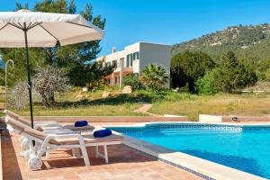 een zwembad met een tafel en stoelen en een parasol bij Can Roca in Illes Balears