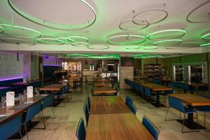 een eetkamer met houten tafels en blauwe stoelen bij Hotel Centro Los Braseros in Burgos