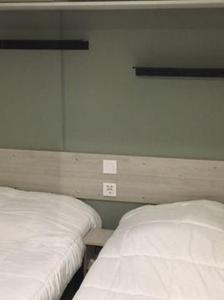 two beds sitting next to each other in a room at mobil-home 468 in Saint-Georges-dʼOléron