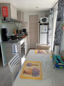 a kitchen with a table and chairs and a kitchen with a tableablish at mobil-home 468 in Saint-Georges-dʼOléron