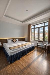 een slaapkamer met een groot bed en een groot raam bij Sunflower Hotel Mộc Châu in Mộc Châu