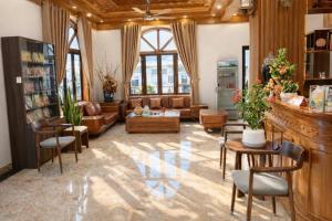 een woonkamer met een bank, een tafel en stoelen bij Sunflower Hotel Mộc Châu in Mộc Châu