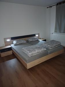 een slaapkamer met een bed met twee kussens erop bij KaTi Hiša 