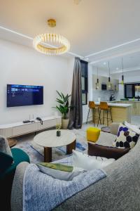 ein Wohnzimmer mit Sofa und Tisch in der Unterkunft The Avery at Lapwing Place in Accra