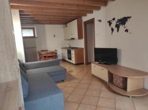 un soggiorno con un divano e un tavolo di Grazioso appartamento con giardino e posto auto a Belluno