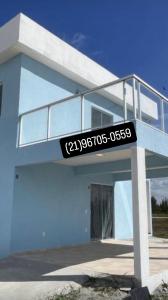 a blue house with a sign on the front of it at Ventos de Arubinha - Apto Inteiro - Reserva a partir de 04 dias em Janeiro e Fevereiro in Arraial do Cabo