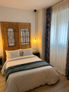 a bedroom with a large bed and a window at La Baltasara Apartments in Valladolid