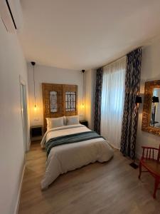 a bedroom with a large bed and a window at La Baltasara Apartments in Valladolid +39 photos