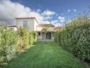 una casa con una siepe di fronte a un cortile di P Minervois G N02 Villa 3P4 a Homps