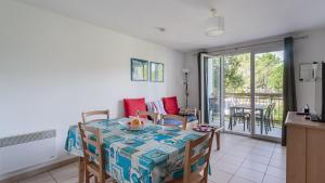 a kitchen and dining room with a table and chairs at Allee des Dunes E N57 3P6 in Ondres