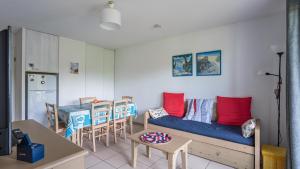 a living room with a couch and a table at Allee des Dunes E N57 3P6 in Ondres +4 photos