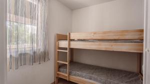 two bunk beds in a room with a window at Allee des Dunes E N57 3P6 in Ondres